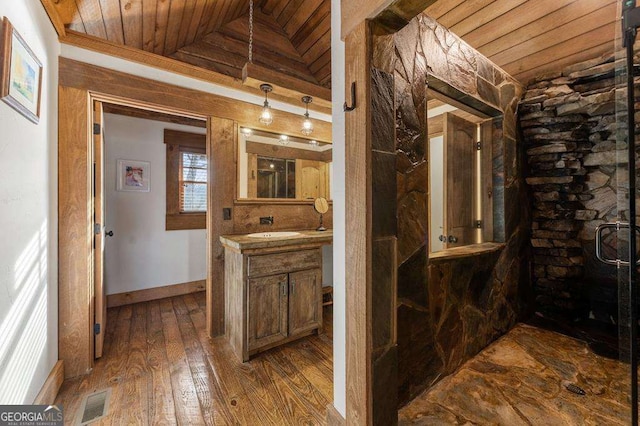 bathroom with vaulted ceiling, hardwood / wood-style flooring, vanity, walk in shower, and wooden ceiling