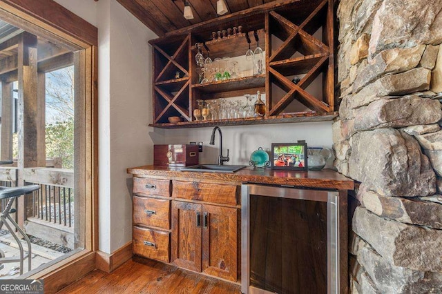 bar with wine cooler, sink, and hardwood / wood-style floors