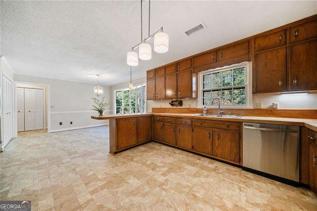 kitchen with hanging light fixtures, stainless steel dishwasher, sink, and a textured ceiling