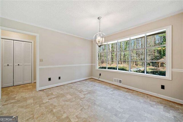 unfurnished dining area with plenty of natural light, a textured ceiling, and a notable chandelier