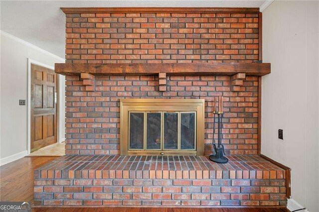 details featuring crown molding, a fireplace, and hardwood / wood-style floors