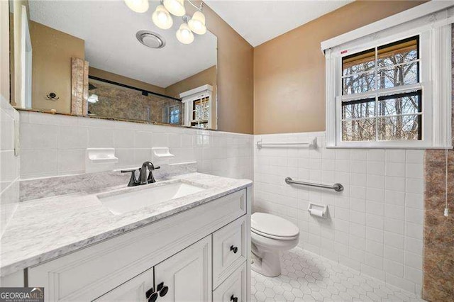 bathroom with vanity, tile patterned floors, tile walls, and toilet