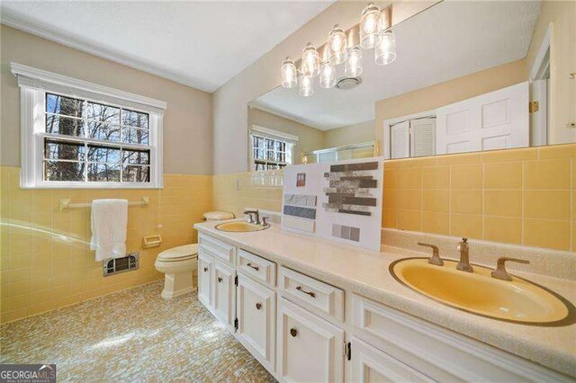 bathroom featuring vanity, a shower, tile walls, and toilet