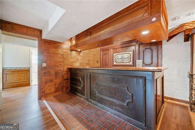 room details featuring hardwood / wood-style floors, a textured ceiling, and wood walls