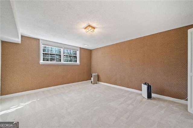 laundry room featuring carpet flooring, radiator heating unit, and a textured ceiling