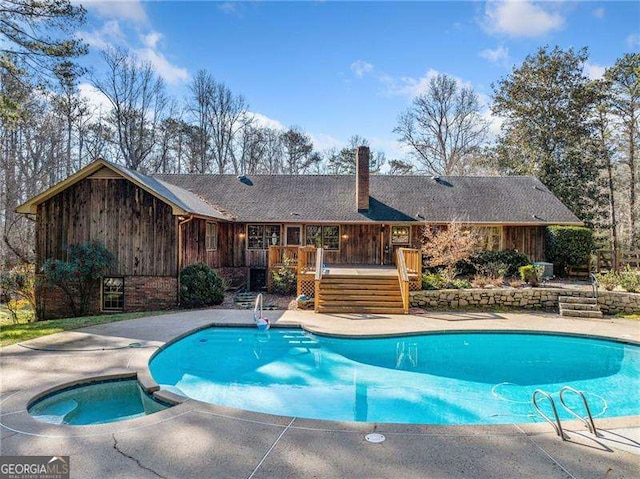 view of pool with a deck and an in ground hot tub