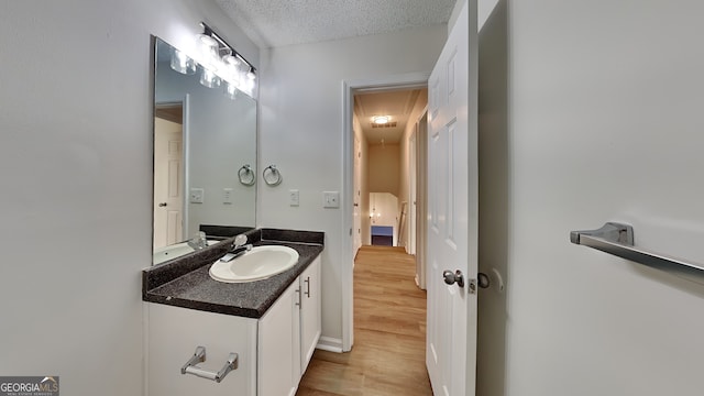 bathroom with vanity, hardwood / wood-style floors, and a textured ceiling