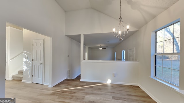 interior space featuring high vaulted ceiling, an inviting chandelier, and light hardwood / wood-style floors