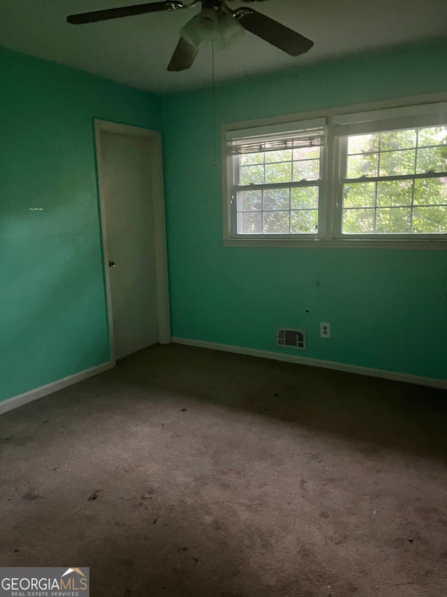 carpeted spare room with ceiling fan