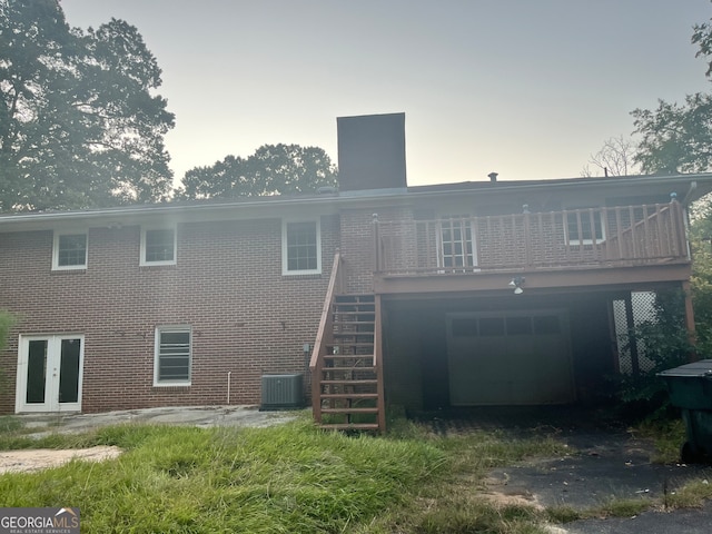 back of property with central AC and a deck