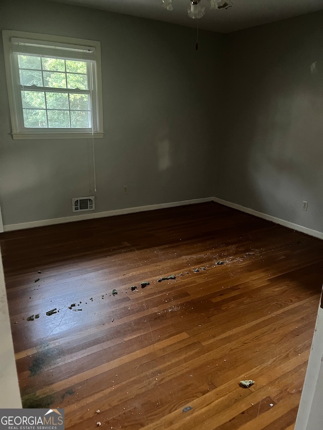 empty room with dark hardwood / wood-style flooring