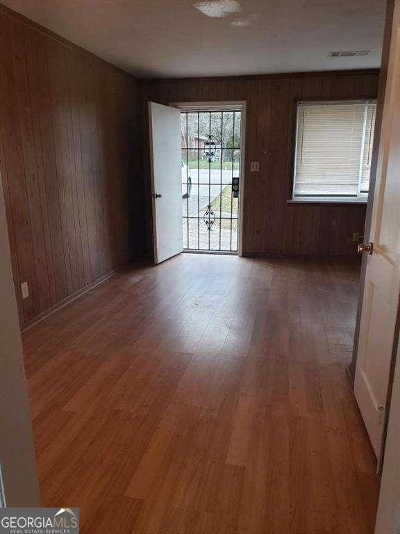 spare room with wood-type flooring and wood walls