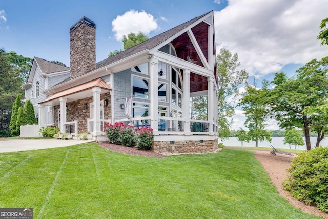 rear view of property featuring a porch and a lawn