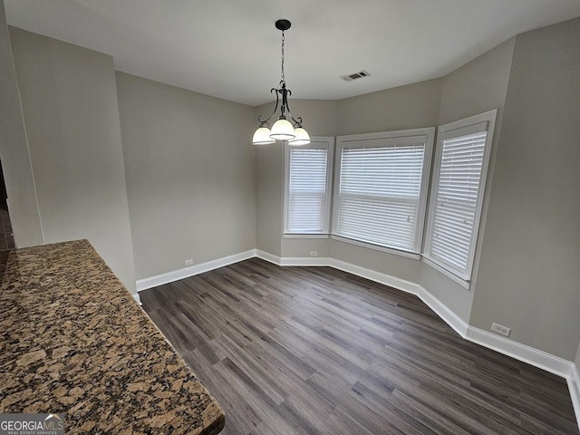 unfurnished dining area featuring dark hardwood / wood-style flooring