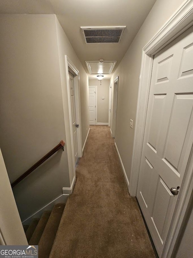 hallway featuring dark colored carpet