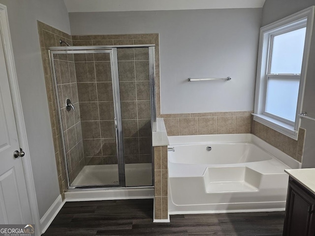 bathroom featuring vanity, hardwood / wood-style floors, and plus walk in shower