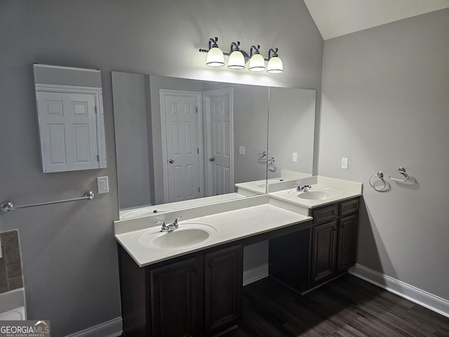 bathroom with vanity, hardwood / wood-style floors, and lofted ceiling