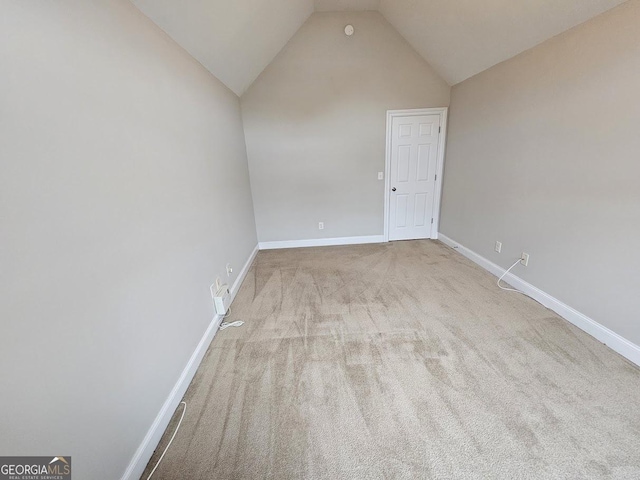 carpeted spare room with lofted ceiling