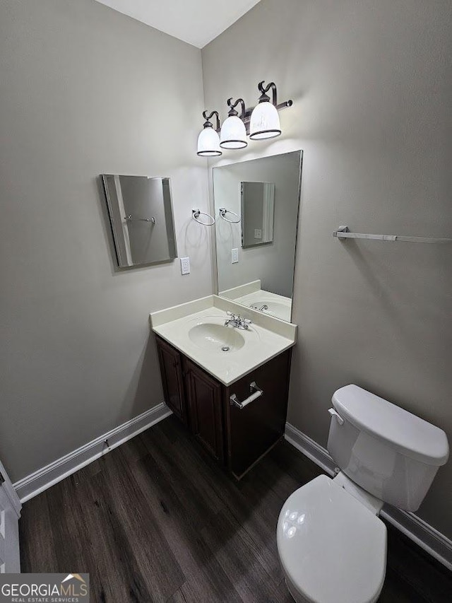 bathroom featuring vanity, wood-type flooring, and toilet