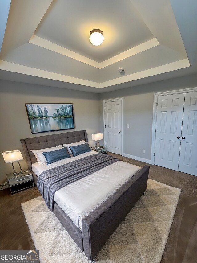 unfurnished bedroom featuring a closet, carpet floors, and a raised ceiling