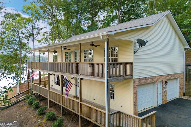 rear view of property featuring ceiling fan, a garage, and covered porch