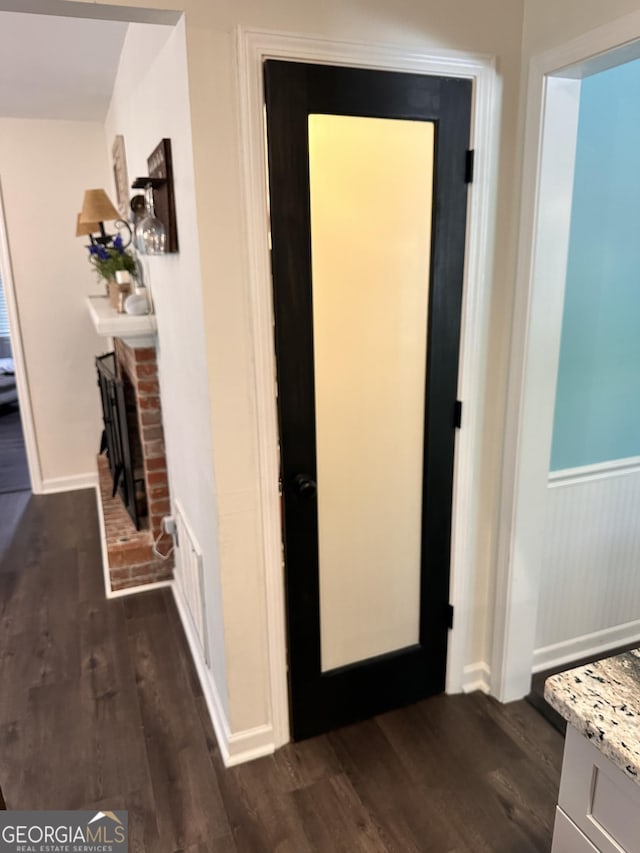 corridor with dark hardwood / wood-style flooring