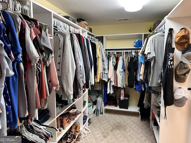 walk in closet with carpet floors