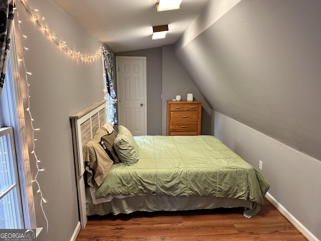 bedroom with hardwood / wood-style flooring and vaulted ceiling