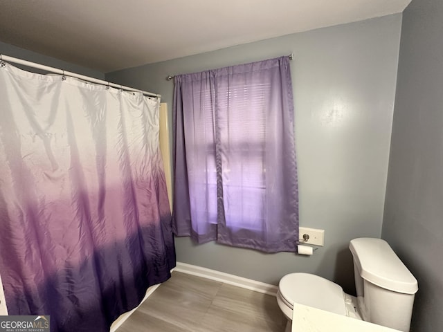 bathroom with shower / bathtub combination with curtain and toilet