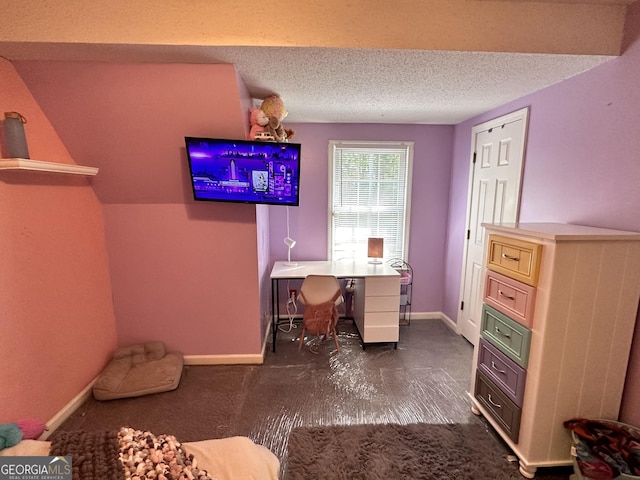 carpeted office featuring a textured ceiling