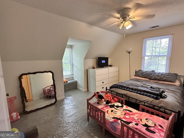 bedroom featuring multiple windows, vaulted ceiling, and a textured ceiling