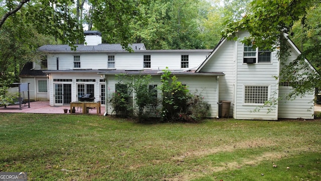 rear view of house featuring a lawn and a patio area