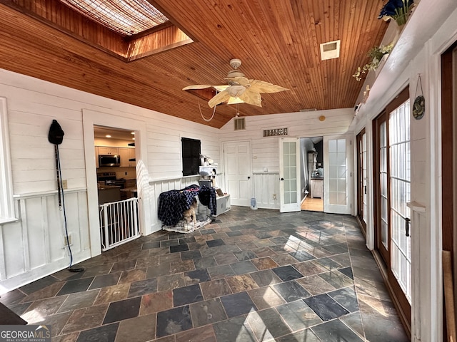 unfurnished sunroom with lofted ceiling with skylight, ceiling fan, and wood ceiling