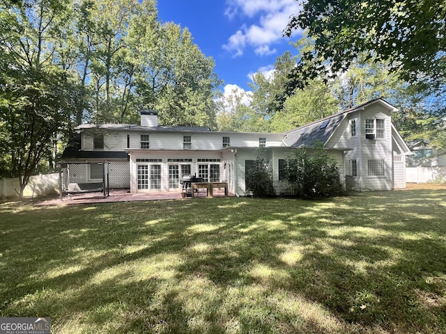 back of property with a yard and a patio area