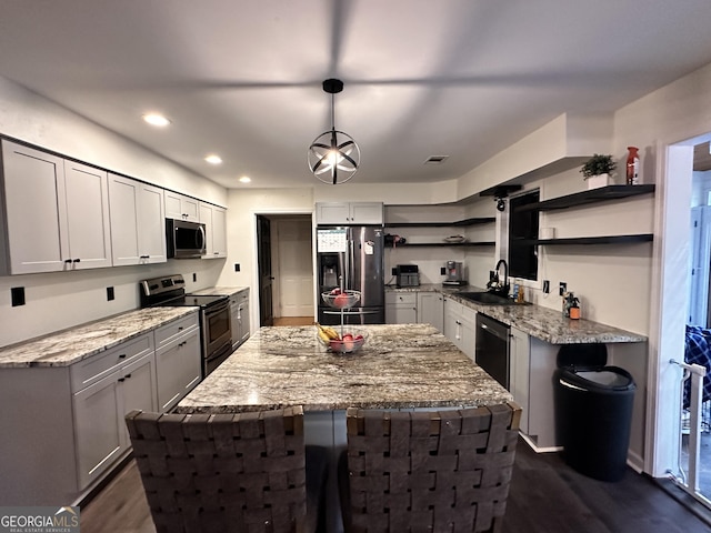 kitchen featuring pendant lighting, stainless steel appliances, light stone countertops, and sink