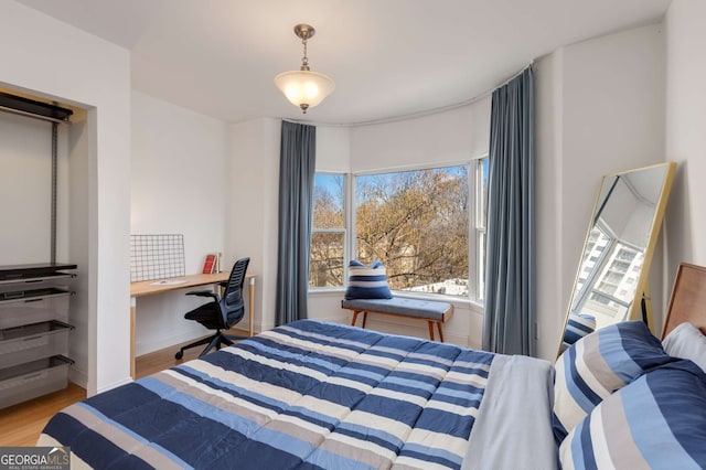 bedroom with wood-type flooring and built in desk