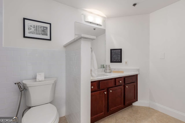 bathroom with vanity, tile walls, tile patterned floors, and toilet