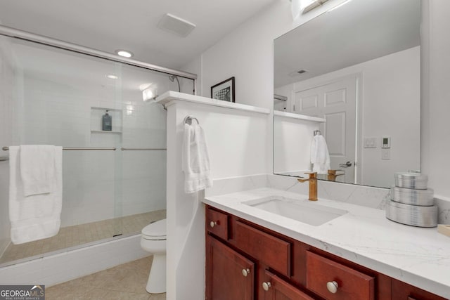 bathroom featuring vanity, tile patterned flooring, a shower with door, and toilet