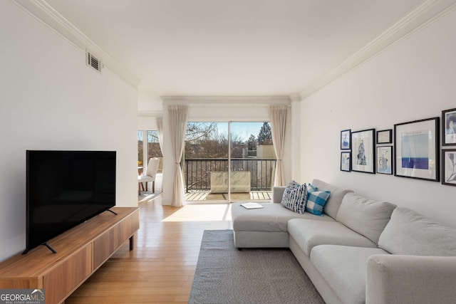 living room with crown molding and light hardwood / wood-style flooring