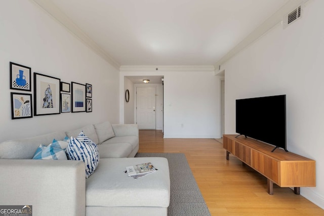 living room with wood-type flooring and ornamental molding