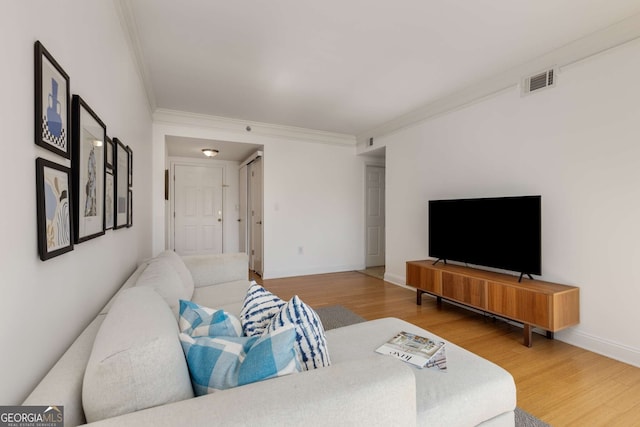 living room featuring hardwood / wood-style flooring and crown molding