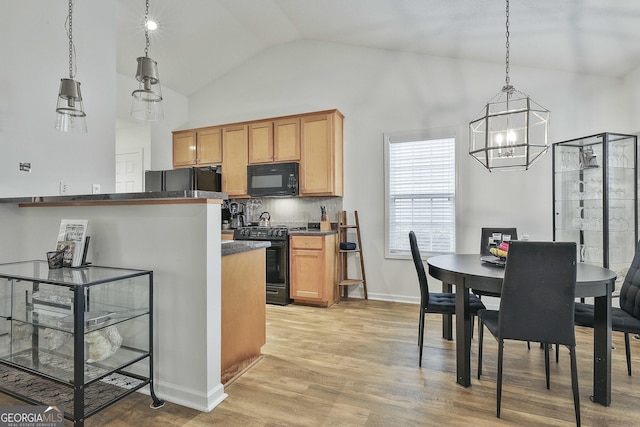 kitchen with decorative light fixtures, black appliances, high vaulted ceiling, light hardwood / wood-style flooring, and backsplash