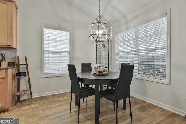 dining room with hardwood / wood-style flooring, a healthy amount of sunlight, and a chandelier