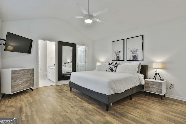 bedroom with ceiling fan, wood-type flooring, connected bathroom, and vaulted ceiling