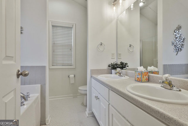 bathroom featuring tile patterned floors, toilet, a bathing tub, and vanity