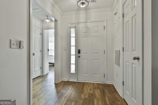 entrance foyer with crown molding, dark wood-type flooring, and a textured ceiling