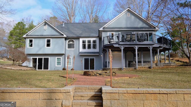 rear view of property featuring a wooden deck and a yard