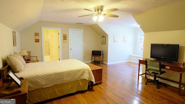 bedroom featuring hardwood / wood-style flooring, vaulted ceiling, a textured ceiling, and ceiling fan