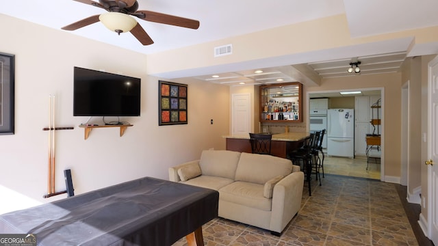 living room with beamed ceiling, ceiling fan, and bar area