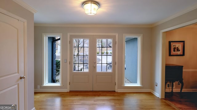 entryway featuring ornamental molding, french doors, and light wood-type flooring